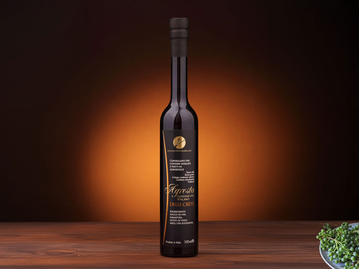Bottle of Agresto Delle Crete, an amber-hued Italian condiment made from apples, dried grapes, figs, and wine vinegar, with fruity and vegetal notes.